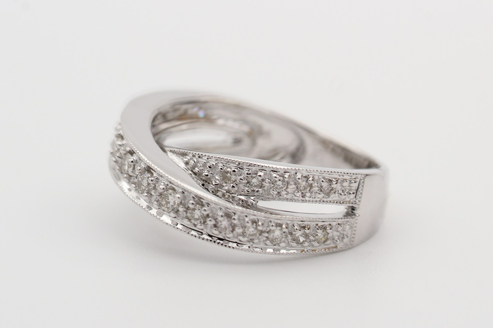 silver diamond ring on white surface